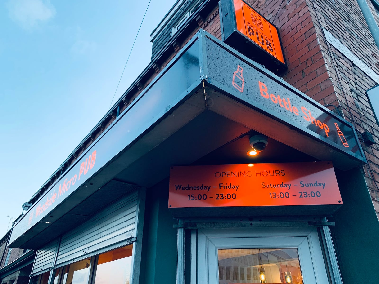 Woodside Micro Pub's orange sign and Bottle Shop fascia on Low Lane
