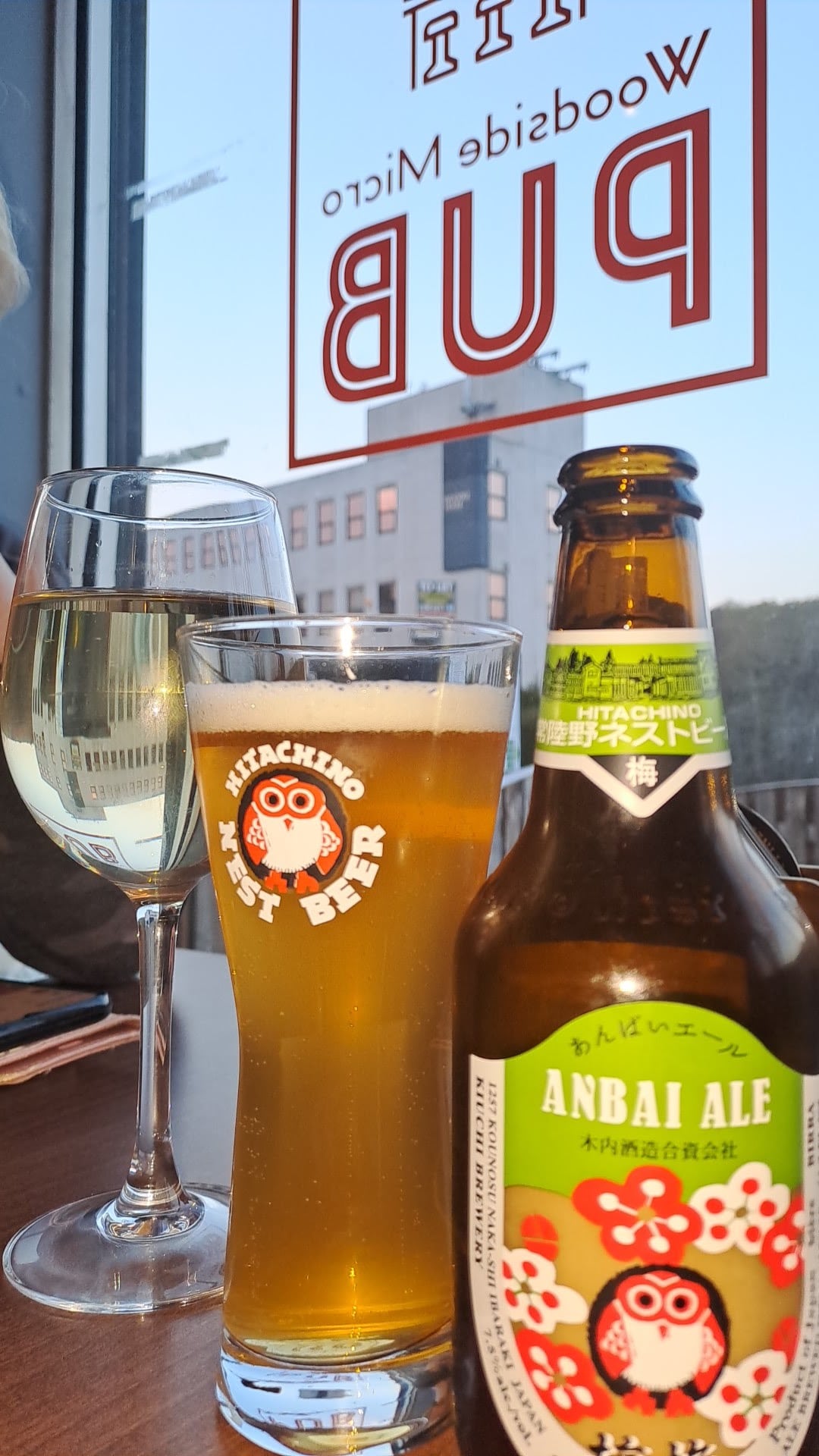 A glass of beer and a bottle beside Woodside Micro Pub's window