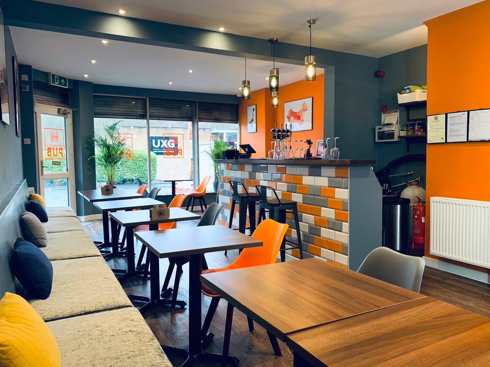 Woodside's intimate bar with orange chairs, teal walls and wooden tables