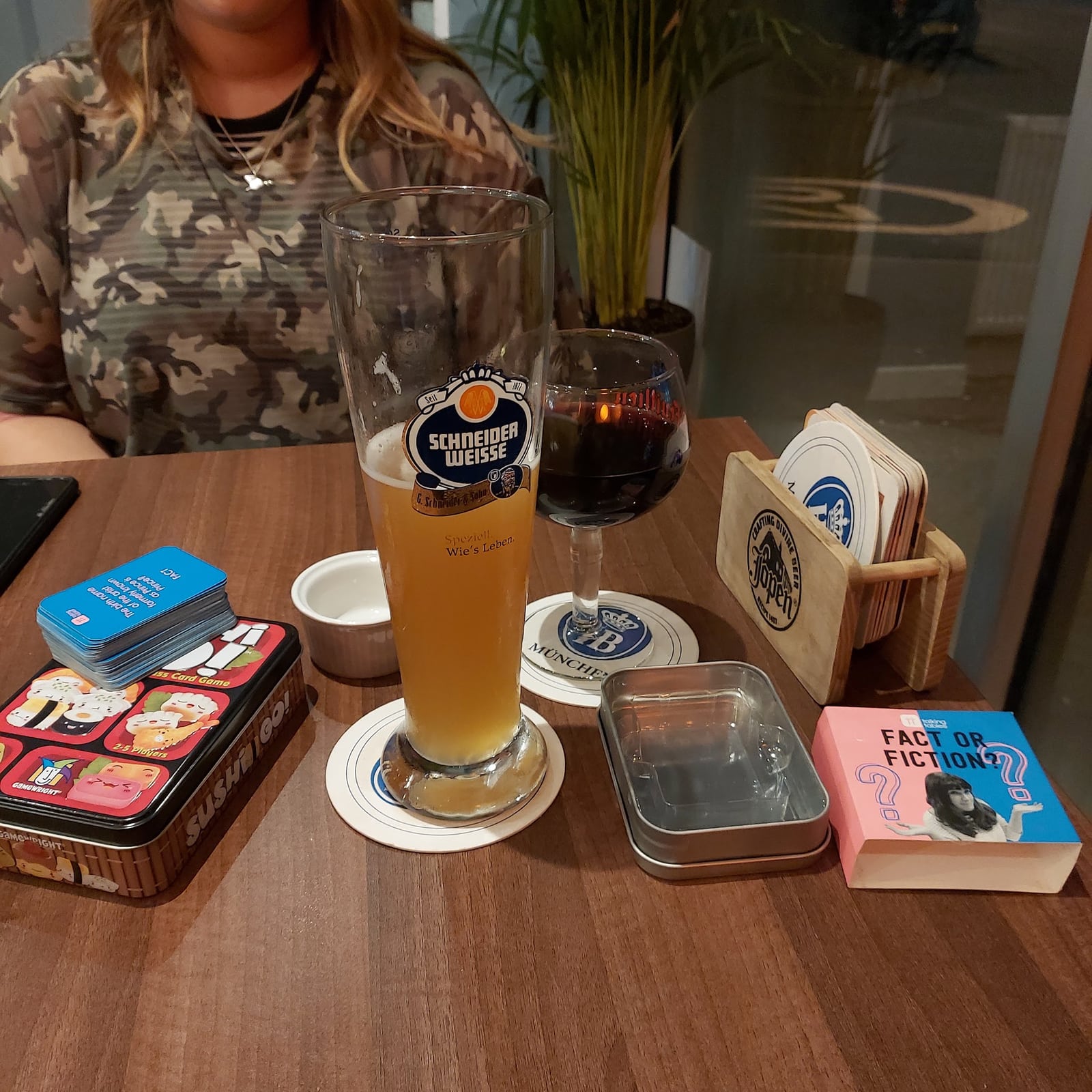 Beer, a glass of wine and board games on a table at Woodside